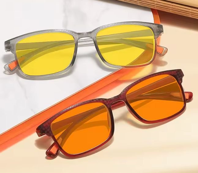 Two colorways side by side: grey frame with yellow lenses and red frame with orange lenses